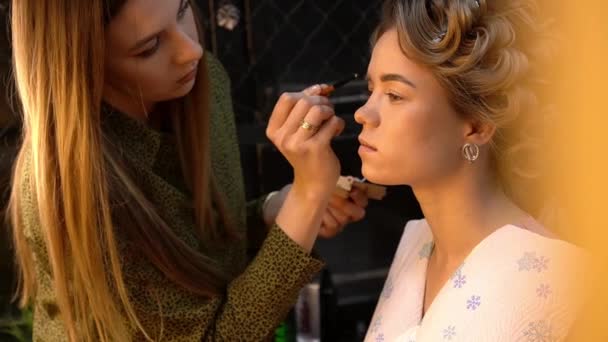 Augenbrauen-Make-up. Professionelle Maskenbildnerin korrigiert Augenbrauen junger Frau mit Pinsel — Stockvideo