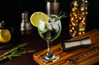 Limonlu taze Mojito kokteyli, biberiye ve koyu mavi arka planda kavanoz bardakta buz. Yaz kokteyli