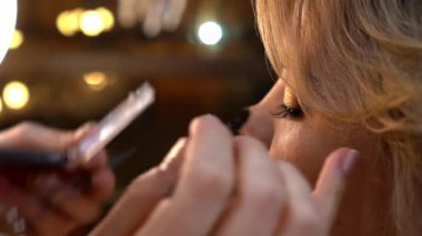 Makyaj sanatçısının kadın bir mankene kirpik uzatma yaptığı gerçek zamanlı video. Yakın çekim.