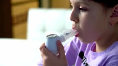 Little girl makes inhalation with medical nebulizer at home. Close up view