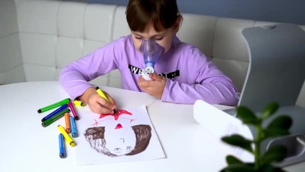 Niña hace inhalación con nebulizador médico mientras está sentada en la mesa y dibuja con marcadores — Vídeo de stock