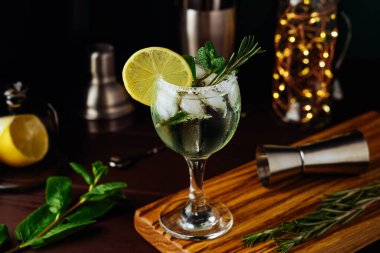 Limonlu, biberiyeli, naneli ve buzlu mojito kokteyli koyu mavi arka planda. Yaz kokteyli
