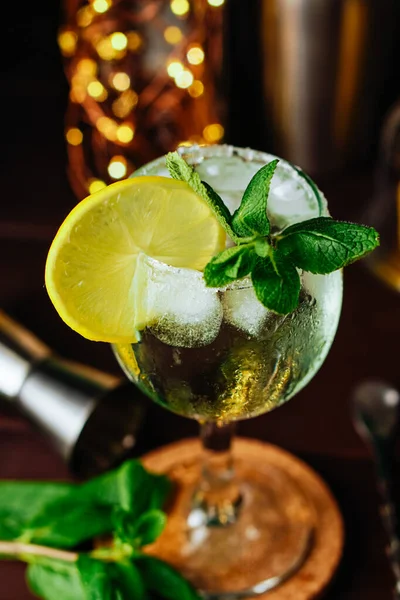 Limonlu, naneli ve buzlu mojito kokteyli koyu mavi arka planda kavanozda. Yaz kokteyli