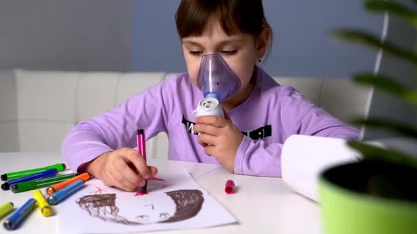 Niña hace inhalación con nebulizador médico mientras está sentada en la mesa y dibuja con marcadores — Vídeo de stock