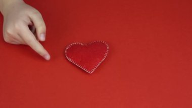 Çocuk kırmızı kalbi elinde tutuyor. Sevgililer Günü, Anneler Günü. Aşk, mutluluk, neşe konsepti