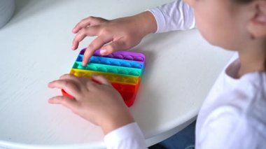 Küçük kız gökkuşağıyla oynuyor, poponu salla. Akıl sağlığı oyuncağı konsepti