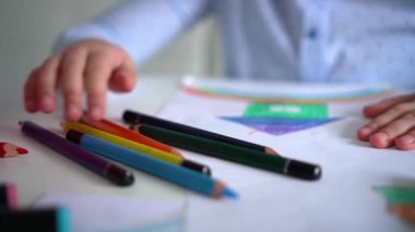 Çocukların yaratıcılığı. Evinde renkli kalemlerle gökkuşağı çizen küçük bir kız çocuğu.