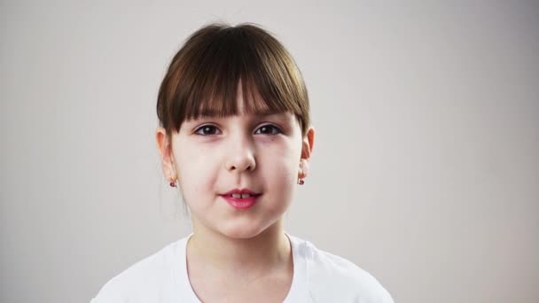 Portret van een klein lachend brunette meisje dat naar de camera kijkt. Close-up schieten — Stockvideo