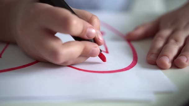 子供はピンクのマーカーで紙に心を描きます。接近中だ。子供の創造性。聖バレンタインデー — ストック動画