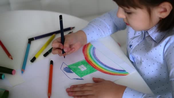 Kinderen creativiteit. Kind meisje tekening regenboog met gekleurde potloden op papier thuis — Stockvideo