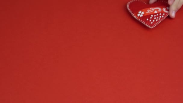 Mädchenhände legen Herz auf roten Tisch. Kind bewegt rotes Herz in Händen. Valentinstag, Muttertag — Stockvideo