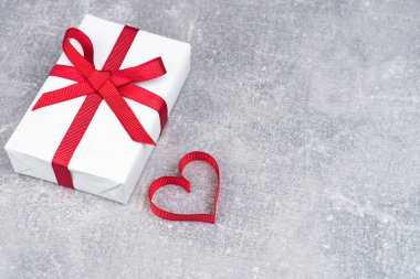 Sevgililer Günü ya da fotokopi çekilen doğum günü konsepti. Kırmızı kurdele kalp ve gri arka planda hediye kutusu