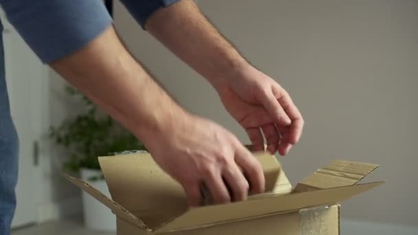 Man packar upp pappkartong, tar fram hårdvara för trämöbler. Självmontering av möbeldelar — Stockvideo