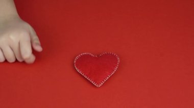 Çocuk kırmızı kalbi elinde tutuyor. Sevgililer Günü, Anneler Günü. Aşk, mutluluk, neşe konsepti