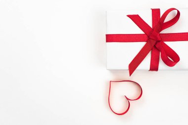 Kırmızı kurdele ve beyaz arka plan üzerinde izole dekoratif kalp ile beyaz kutuları