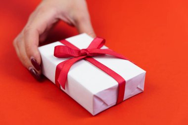 Kırmızı kurdeleli beyaz hediye kutusu olan bir kadın. Sevgililer Günü ya da doğum günü öncesi konsepti