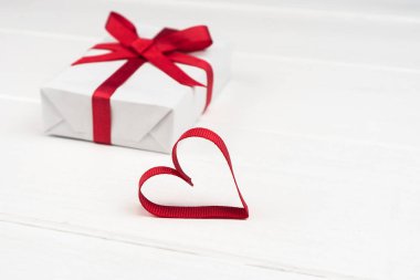 Sevgililer Günü ya da fotokopi çekilen doğum günü konsepti. Kırmızı kurdele kalp ve beyaz tahta üzerinde hediye kutusu.