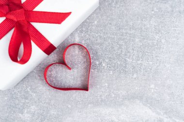 Sevgililer Günü ya da fotokopi çekilen doğum günü konsepti. Kırmızı kurdele kalp ve gri arka planda hediye kutusu