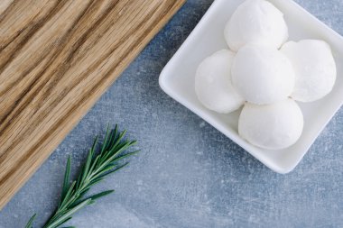 Taze İtalyan beyaz peyniri mozzarella bufalosu beyaz kâse içinde taze biberiye dalıyla servis edilir.