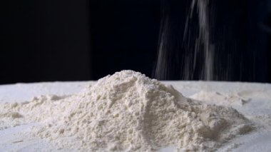 Şefin elleri masandaki una dokunuyor. Fırın işçisi ekmek pişirmeden önce malzemeleri kontrol ediyor.