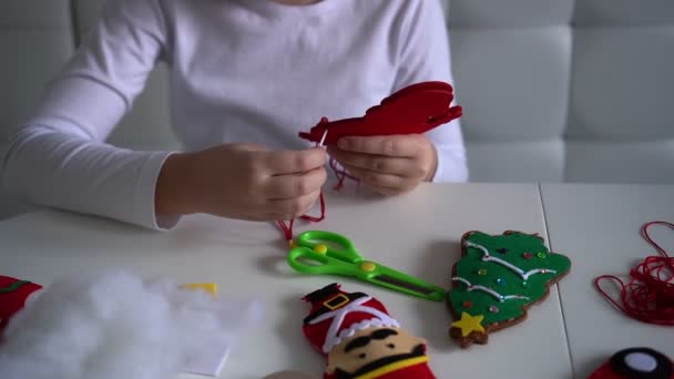 子供の女の子は織物を見たクリスマスツリーの装飾のためのサンタを感じた。子供のお祝い手作りのダイコンセプト — ストック動画