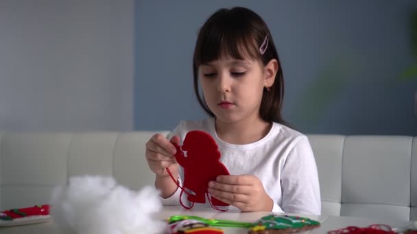Gyermek lány varrni textil érezte Mikulás karácsonyfa dekoráció. Gyerekek ünnepi kézzel készített diy koncepció — Stock videók
