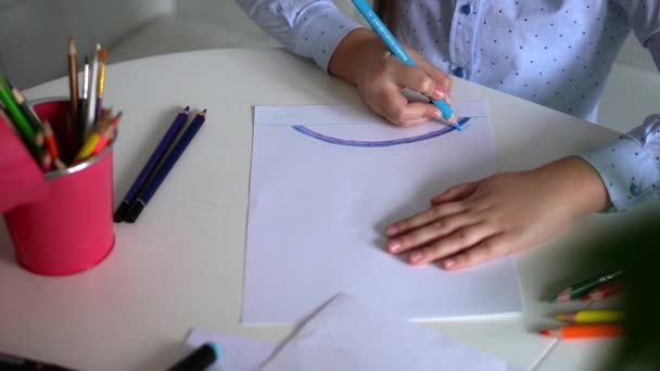Παιδική δημιουργικότητα. Παιδί κοριτσάκι σχέδιο ουράνιο τόξο με χρωματιστά μολύβια σε χαρτί στο σπίτι — Αρχείο Βίντεο