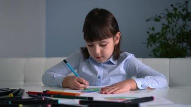 Çocukların yaratıcılığı. Evinde renkli kalemlerle gökkuşağı çizen küçük bir kız çocuğu.