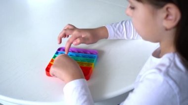 Küçük kız gökkuşağıyla oynuyor, poponu salla. Akıl sağlığı oyuncağı konsepti