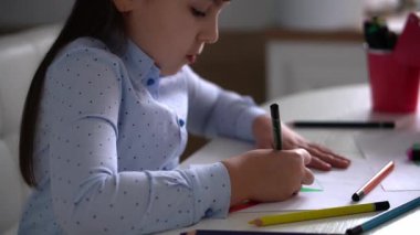 Çocukların yaratıcılığı. Evinde renkli kalemlerle gökkuşağı çizen küçük bir kız çocuğu.