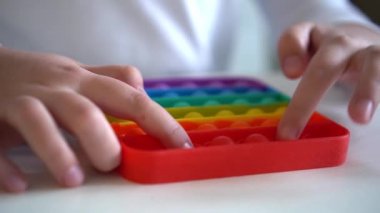 Kız elleri gökkuşağı pop müziğiyle oynarken yakınlaşıyor. Akıl sağlığı oyuncağı konsepti