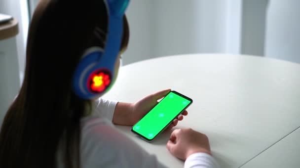 戴着装有绿色显示屏的智能手机的孩子的背影 — 图库视频影像