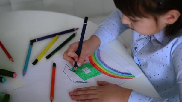 Παιδική δημιουργικότητα. Παιδί κοριτσάκι σχέδιο ουράνιο τόξο με χρωματιστά μολύβια σε χαρτί στο σπίτι — Αρχείο Βίντεο