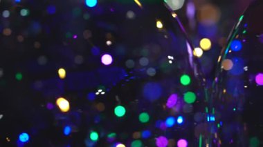 Çok renkli, ışıldayan, soyut, ışıltılı, yuvarlak, parlak ışık, siyah arkaplanlı, maviye boyanmış.