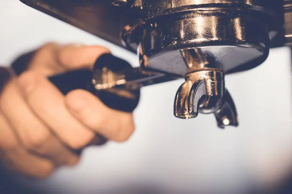 Kahve makinesine koyarken portafilter tutacağı tutan baristaya yaklaş.