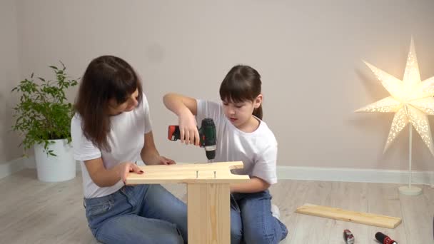 快乐的家庭母亲和女儿一起组装木制家具和螺丝刀。DIY概念 — 图库视频影像