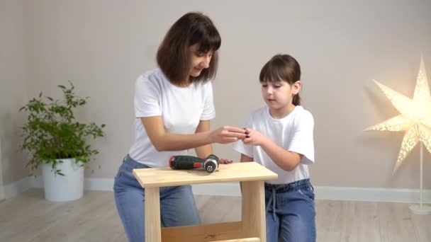 快乐的家庭母亲和女儿一起组装木制家具和螺丝刀。DIY概念 — 图库视频影像