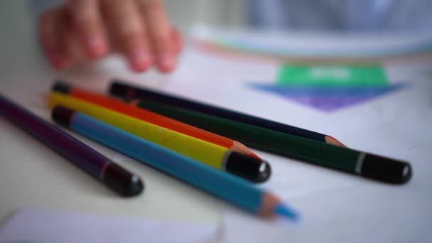 Die Kreativität der Kinder. Kleines Mädchen zeichnet zu Hause Regenbogen mit Buntstiften auf Papier — Stockvideo