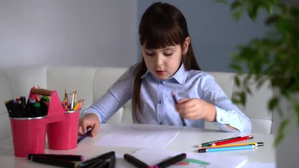 Criatividade infantil. Criança menina desenho arco-íris com lápis coloridos em papel em casa — Vídeo de Stock