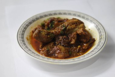 Beyaz tabakta Karahi tavuğu mu yoksa güzel dekorasyon fotoğrafında yemek mi?