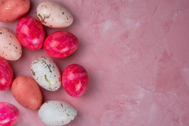 Pembe arkaplanda renkli paskalya yumurtaları, üst görünüm, kopyalama alanı.