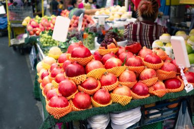 Açık pazardaki tezgahta büyük kırmızı elmalar yığını.