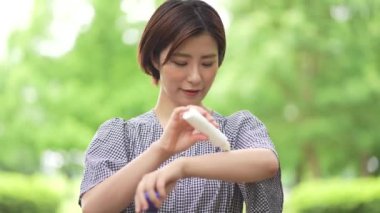 Güneş kremi süren bir kadın resmi