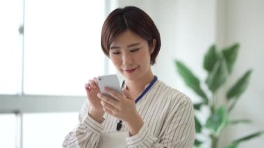 Akıllı telefon kullanan ve elle daire çizen bir kadın. 