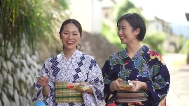ヨーヨーで歩く浴衣の女性と揚げ麺 — ストック動画