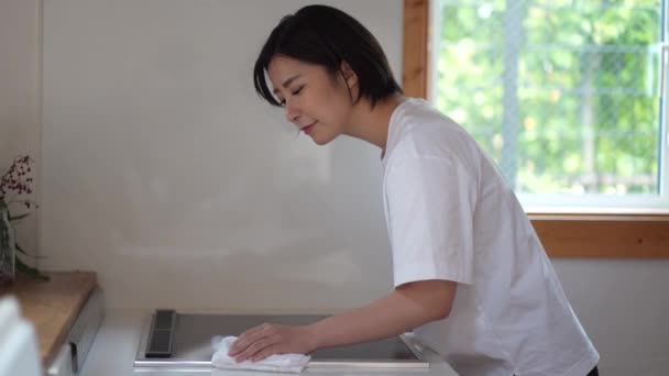 Γυναίκα Σκουπίζει Θερμαντήρα Μαγειρέματος — Αρχείο Βίντεο