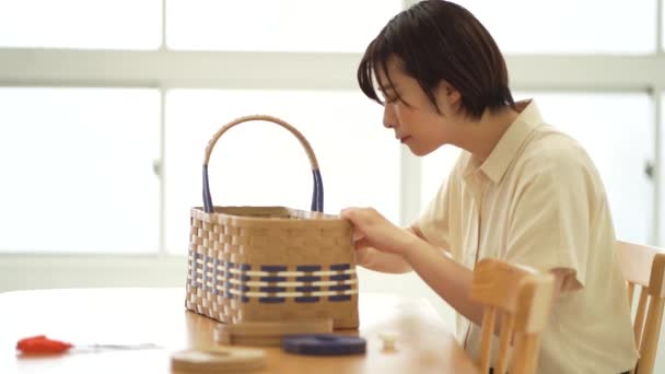 一个女人用手工操作的带子做篮子 — 图库视频影像