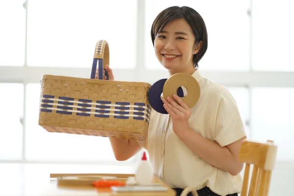 A woman with a craft band and a basket made with a craft band