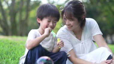 Ebeveynler ve çocuklar sabun köpüğüyle oynuyorlar