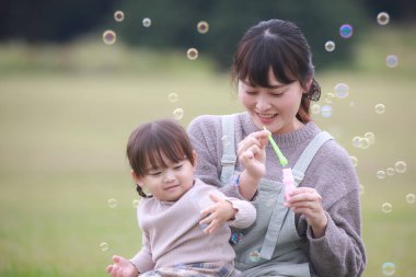 Ebeveynler ve çocuklar sabun köpüğüyle oynuyorlar